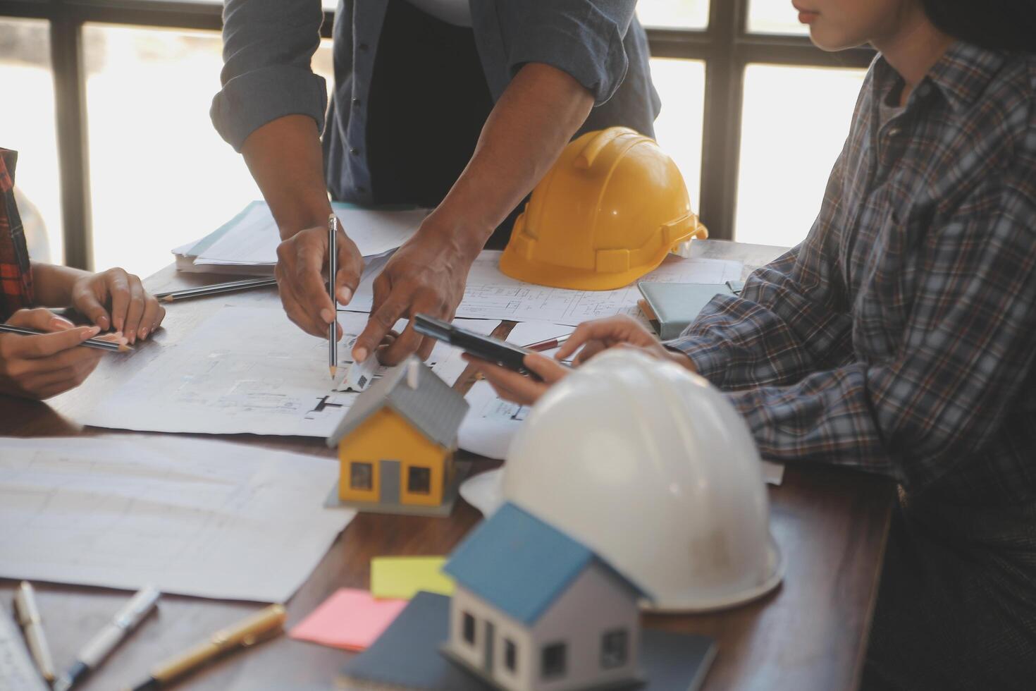 A team of construction engineers talks to managers and construction workers at the construction site. Quality inspection, work plan, home and industrial building design project photo