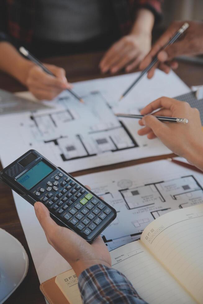 A team of construction engineers talks to managers and construction workers at the construction site. Quality inspection, work plan, home and industrial building design project photo