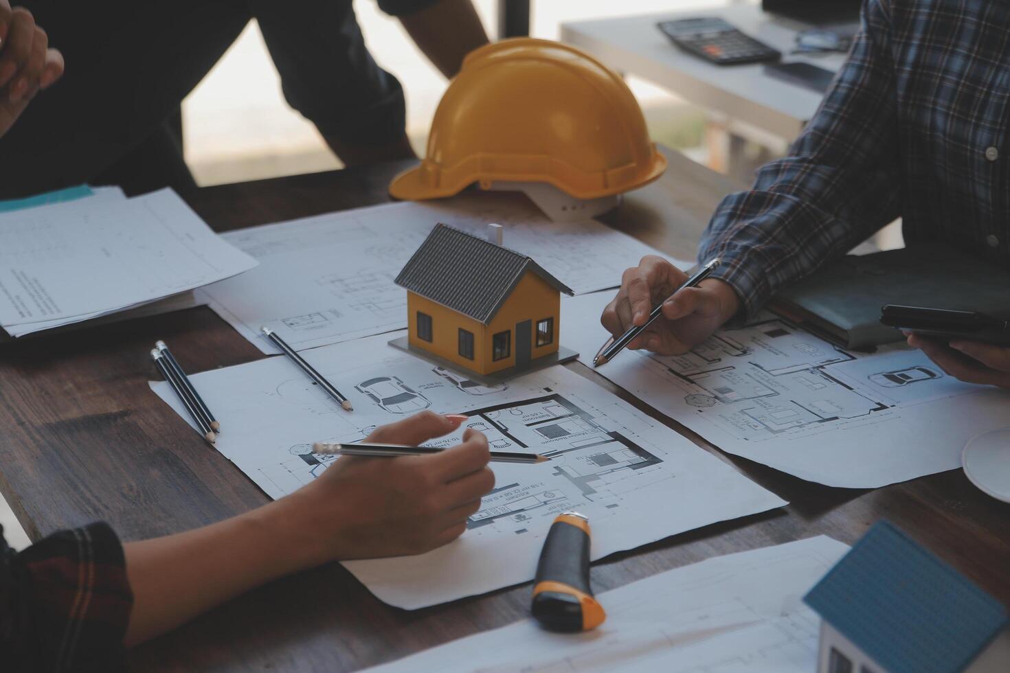 un equipo de construcción ingenieros negociaciones a gerentes y construcción trabajadores a el construcción sitio. calidad inspección, trabajo plan, hogar y industrial edificio diseño proyecto foto