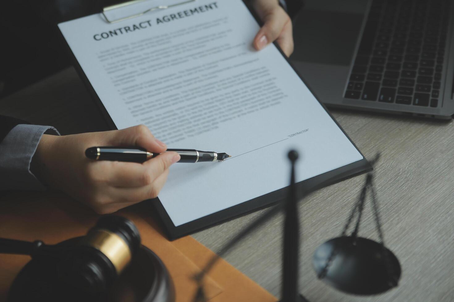 Business and lawyers discussing contract papers with brass scale on desk in office. Law, legal services, advice, justice and law concept picture with film grain effect photo