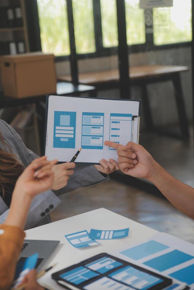 Close up ux developer and ui designer use augmented reality brainstorming about mobile app interface wireframe design on desk at modern office.Creative digital development agency photo