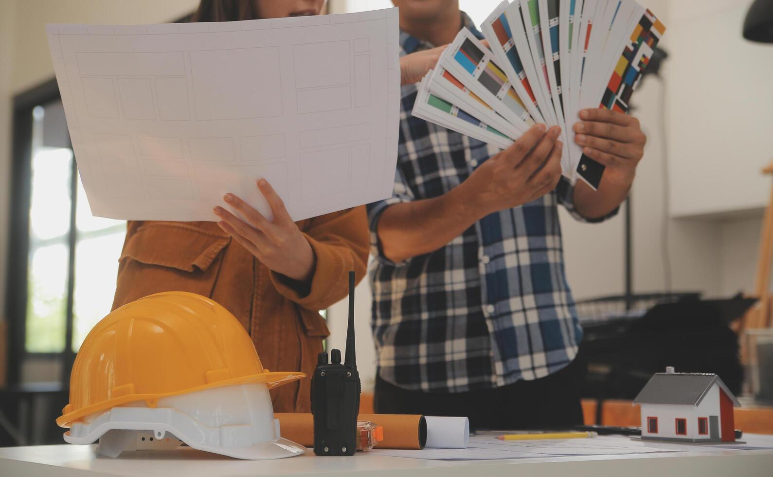 Male and Female Industrial Engineers in Hard Hats Discuss New Project while Using Laptop. They Make Showing Gestures.They Work in a Heavy Industry Manufacturing Factory. photo