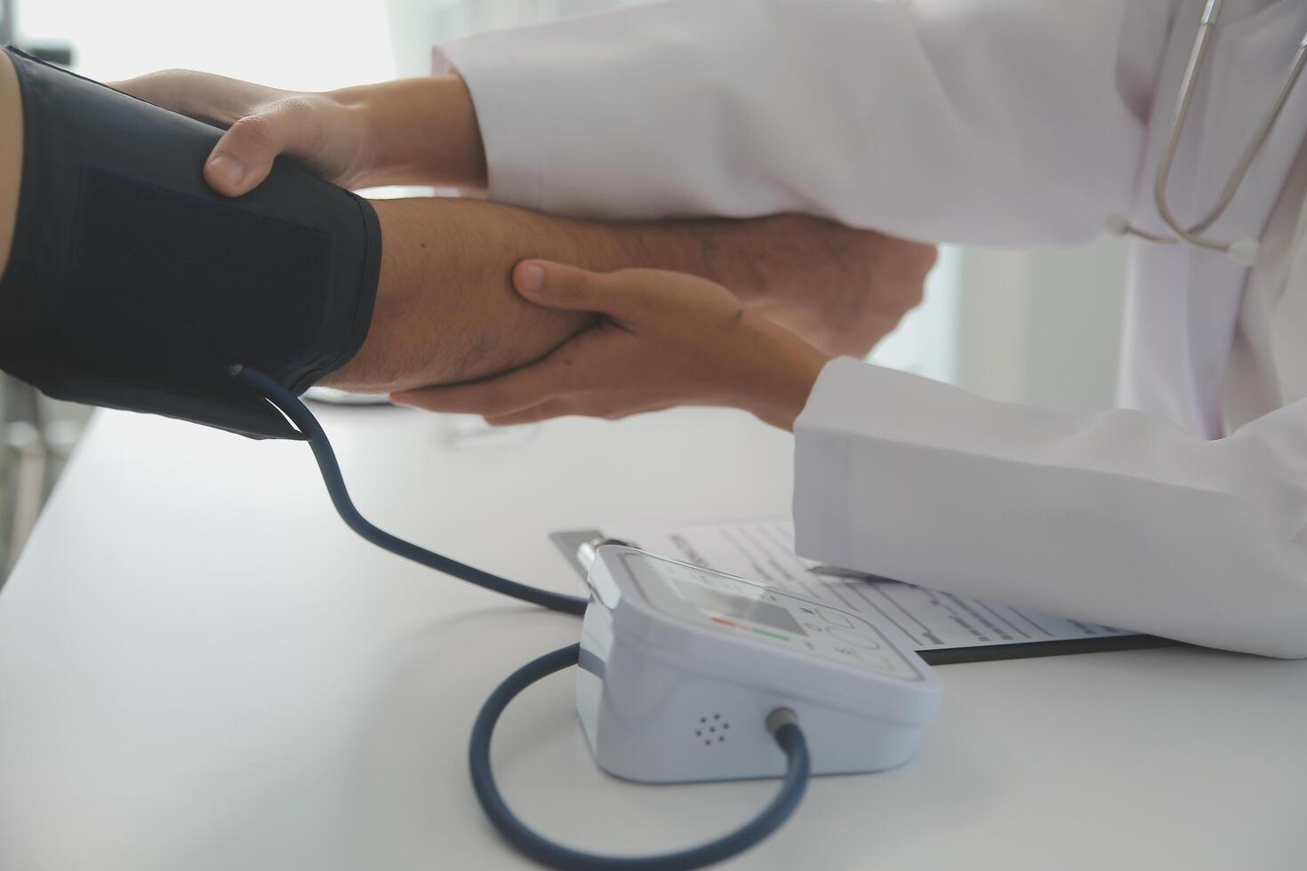 Male doctor uses a blood pressure monitor to check the body pressure and pulse of the patients who come to the hospital for check-ups, Medical treatment and health care concept. photo