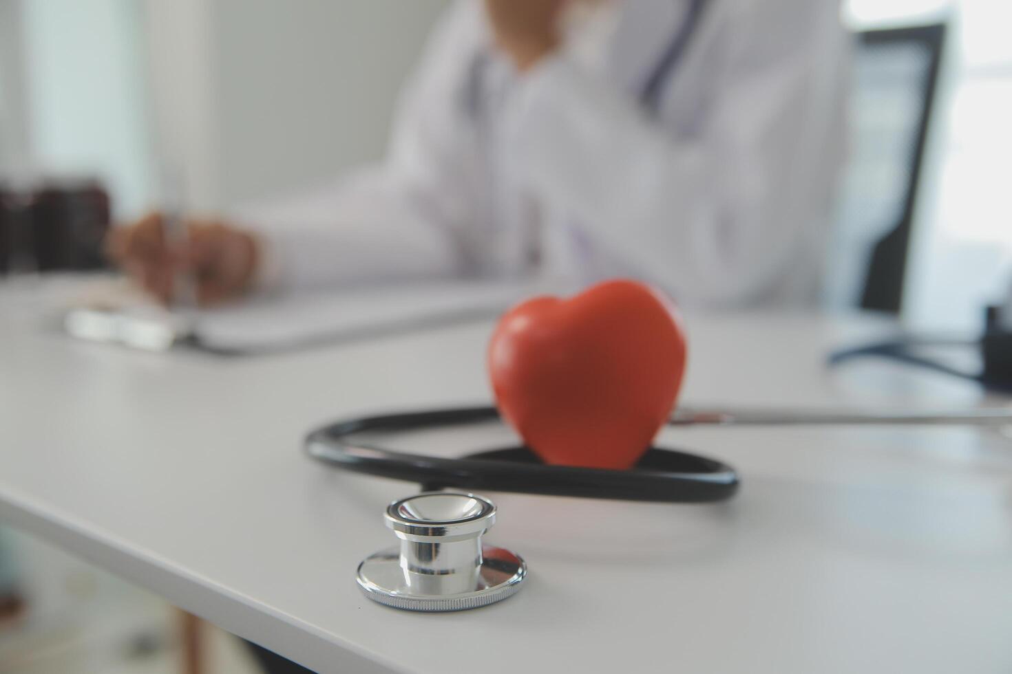 manos de médico mujer participación rojo corazón, demostración símbolo de amar, humano apoyo a paciente, promoviendo médico seguro, temprano chequeo para cuidado de la salud, cardiólogo ayuda. cerca arriba de objeto foto