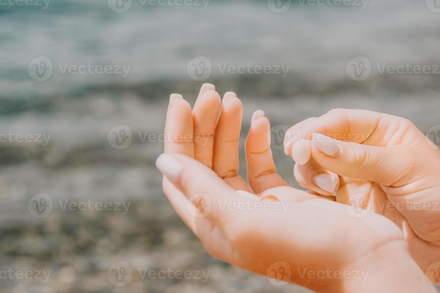 Woman eating milky almond nuts. A young caucasian woman chopping fresh green almond after morning fitness yoga near sea. Only hands are visibly. Healthy vegan food. Slow motion. Close up photo