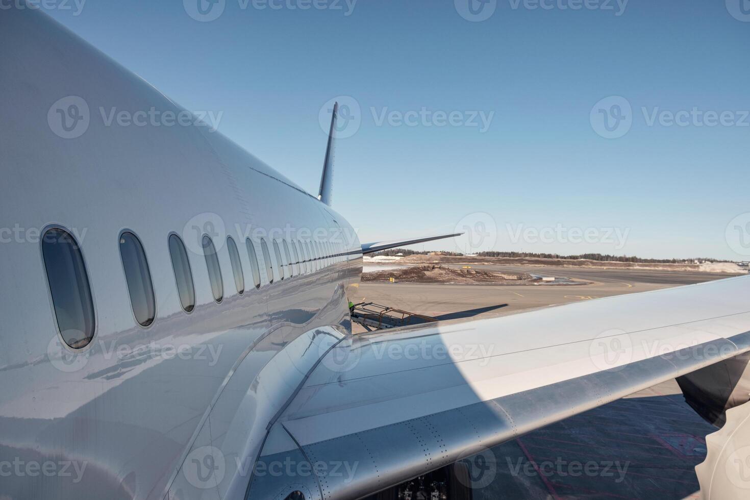 Wing of airplane with windows on runway photo