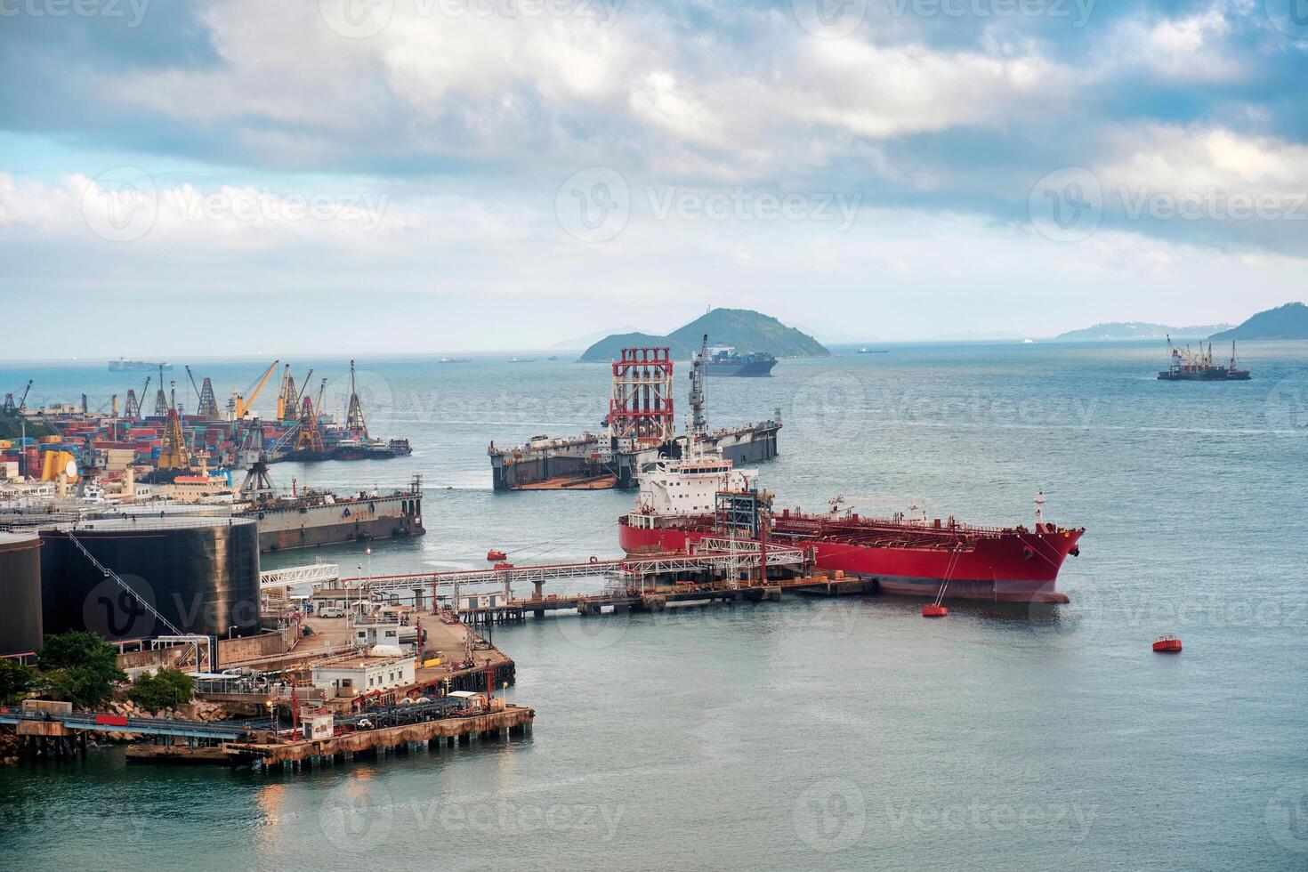 Large carrier cargo ship loading and working industrial crane at the port of an oil refinery photo