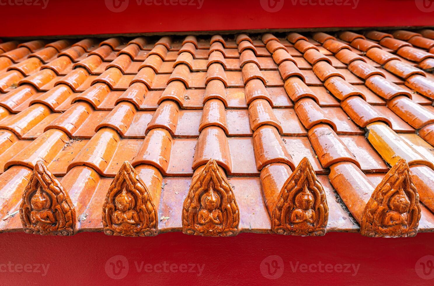 Terracotta tiled roof with carved buddha design photo