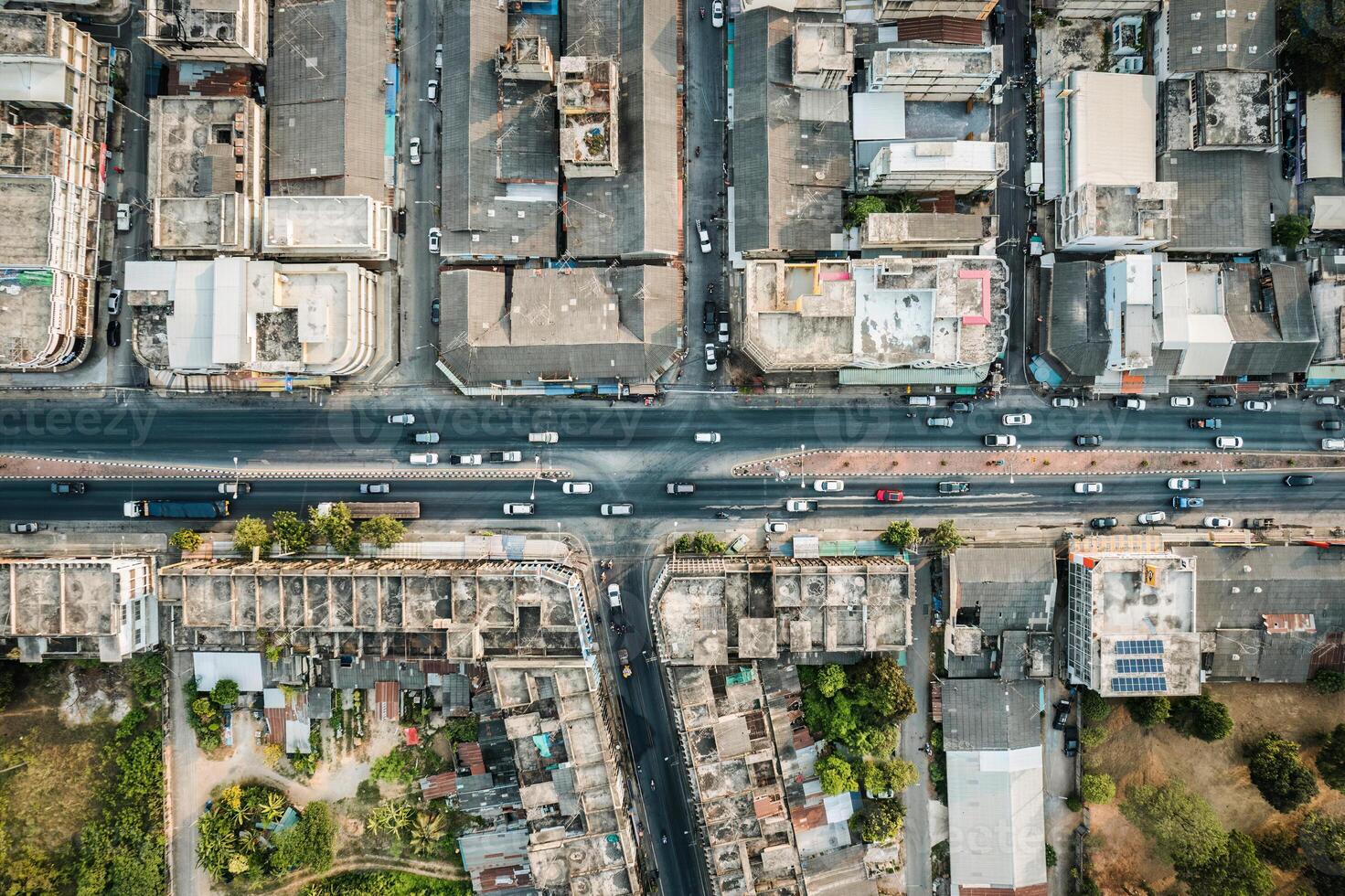 Above of car driving on highway road with local village and commercial building in suburban photo