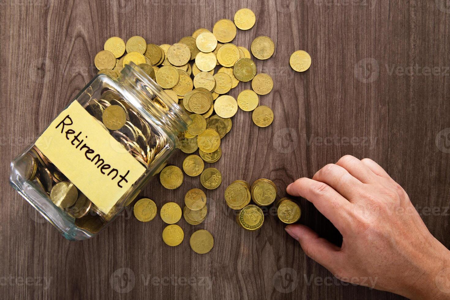 Coin glass jar container on wooden desk, retirement saving concept photo