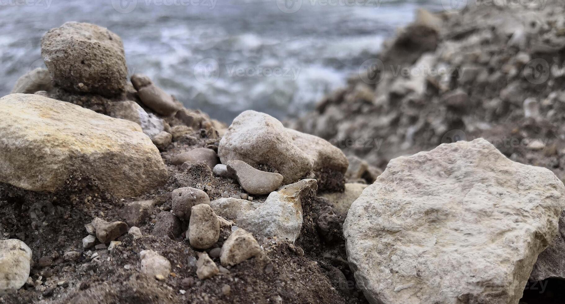 Rock Formation by Beach With Water in Background photo