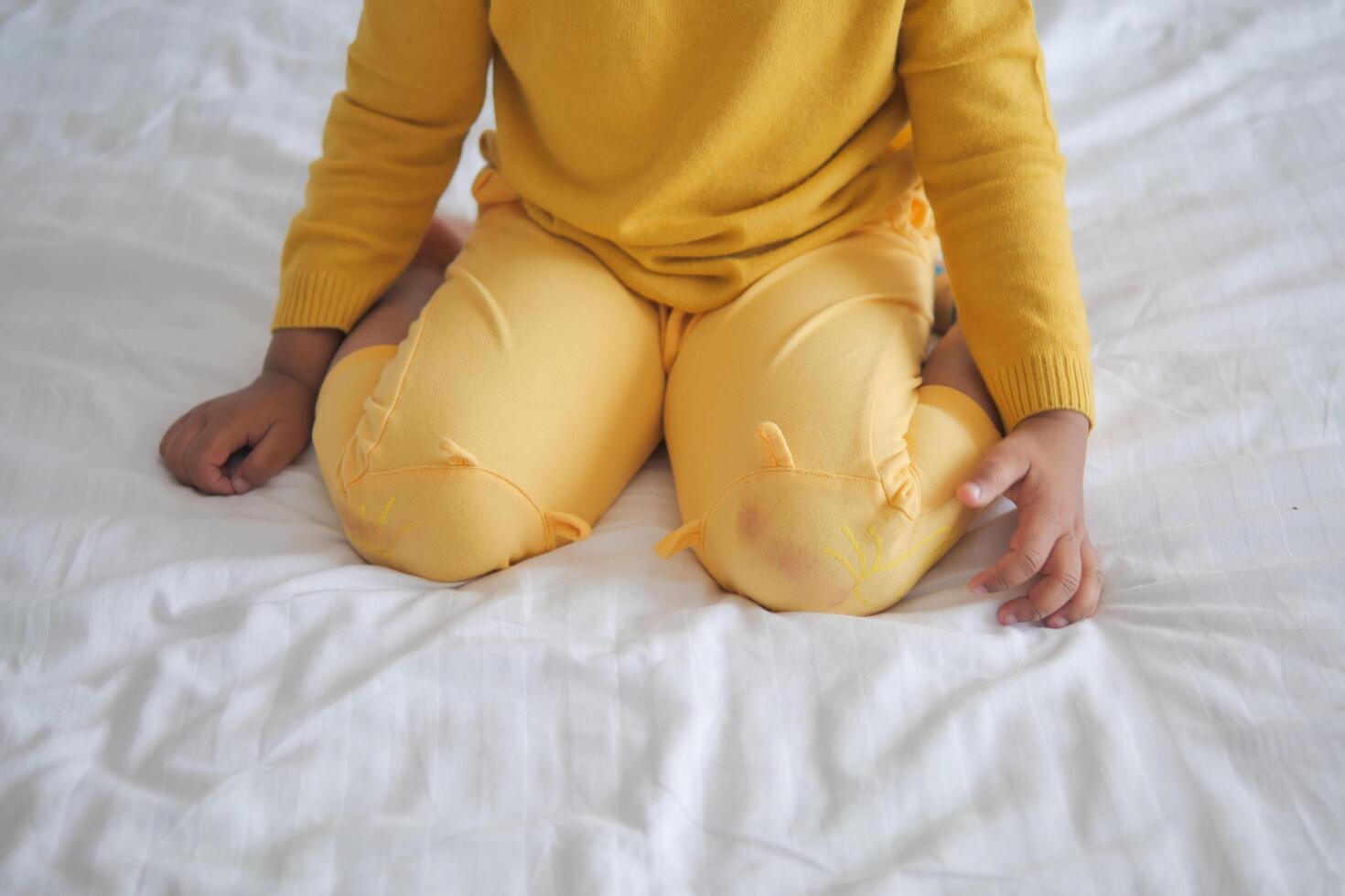 child sitting W posture on the bed photo