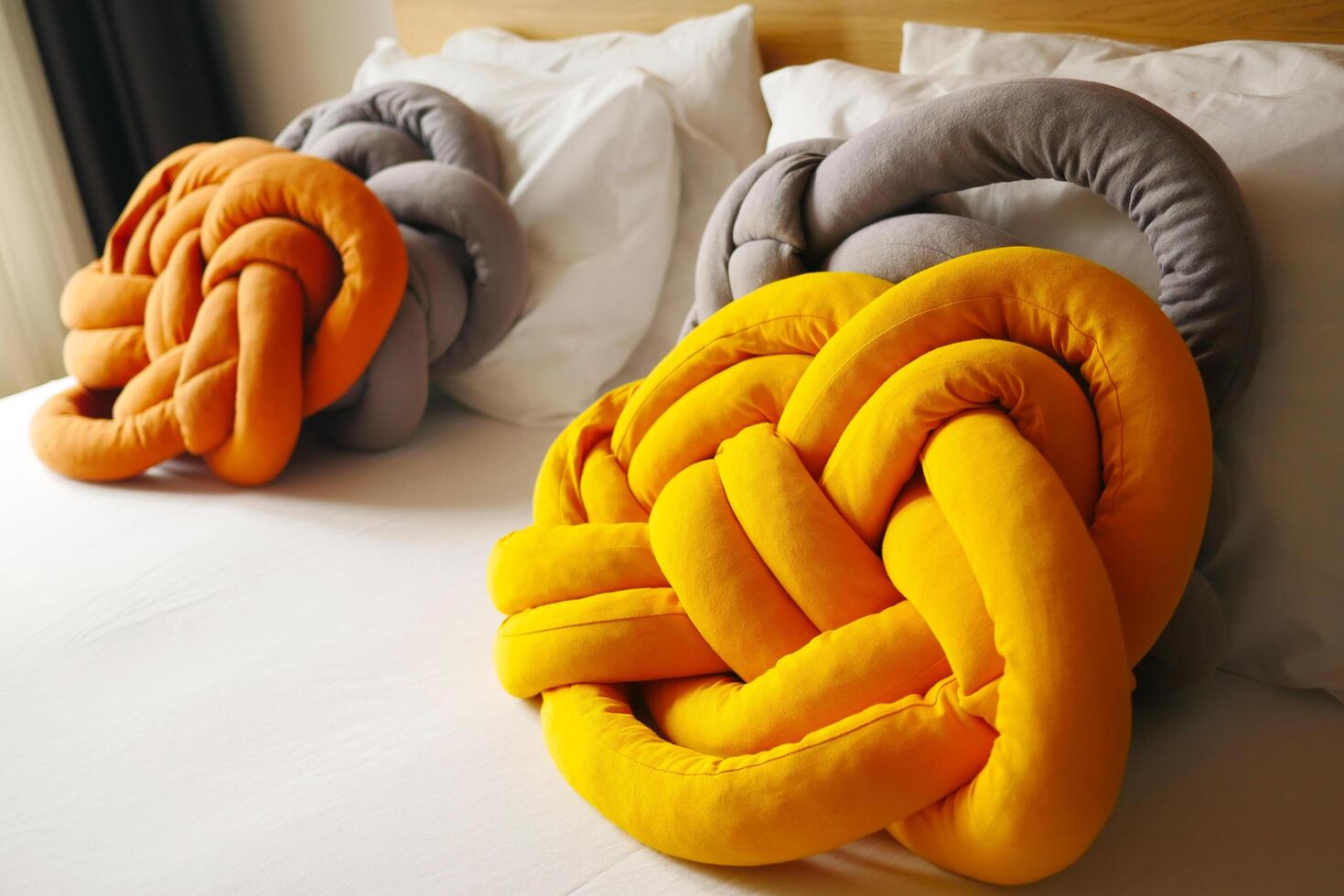 three knotted pillows are sitting on a bed photo