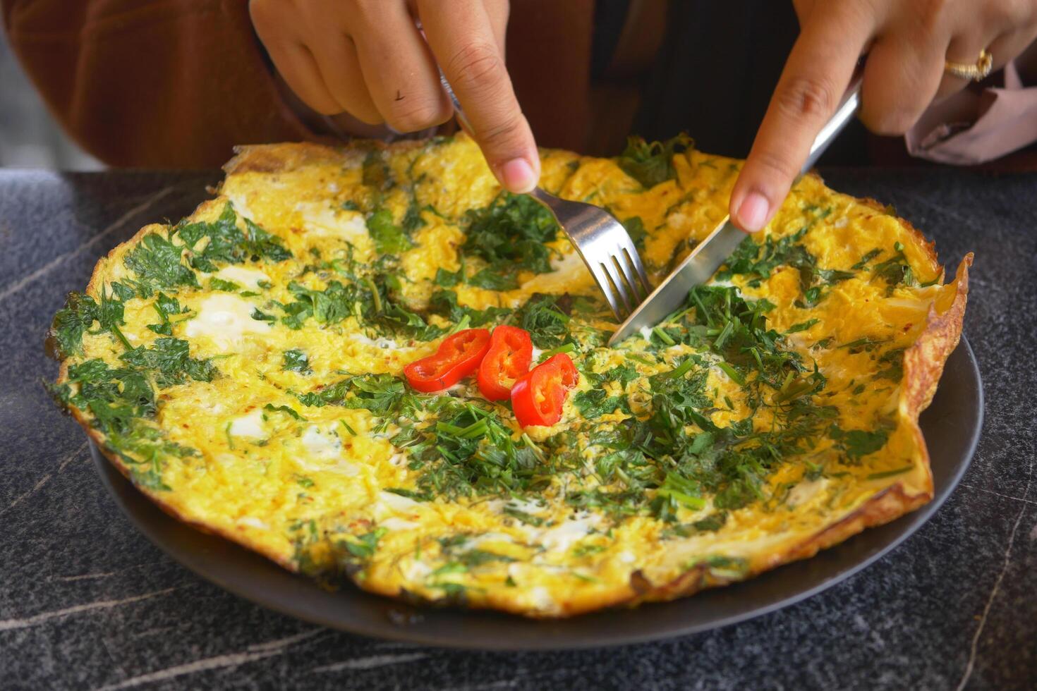 women eating herb Egg Omelette on table photo