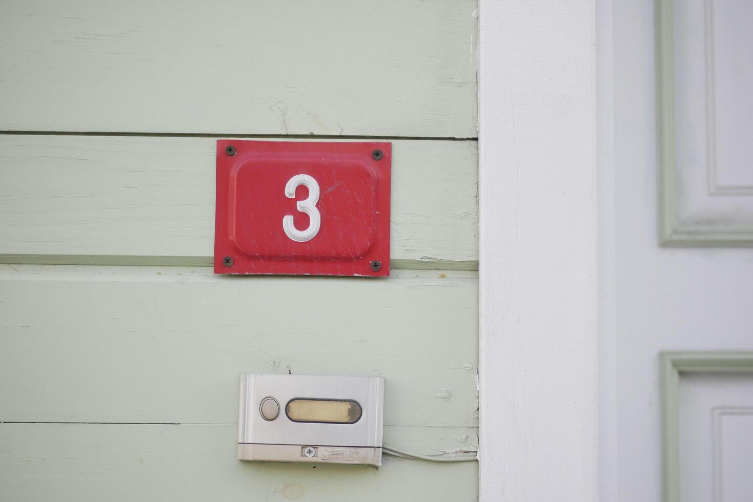 house number three. Decorative lettering on a brick wall. photo