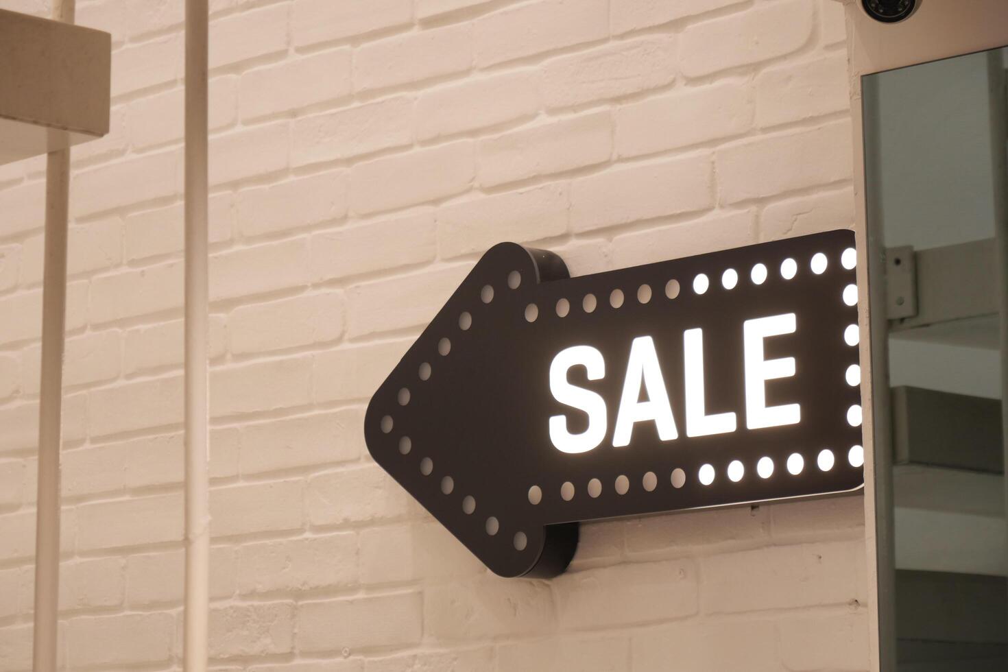 sale sign with arrow hanging on wall photo