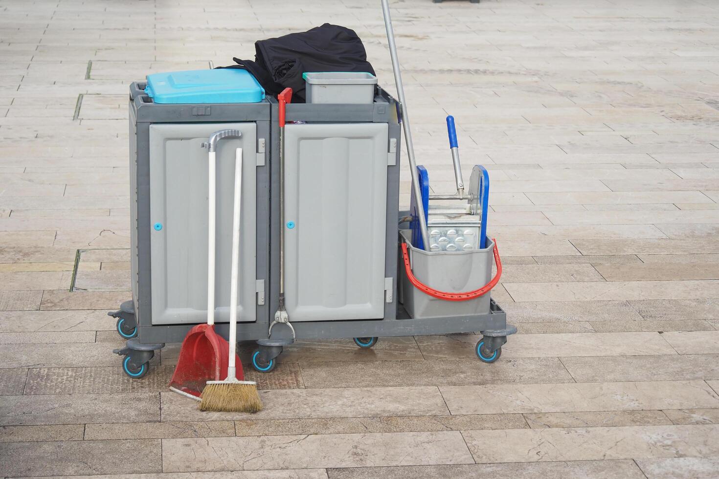 A gaspowered cleaning machine with a rolling cart, broom, and mop photo