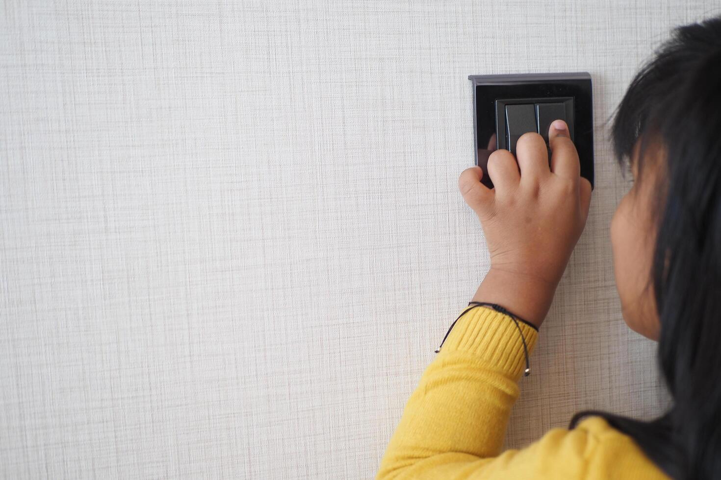 child finger turning on lighting switch with copyspace photo