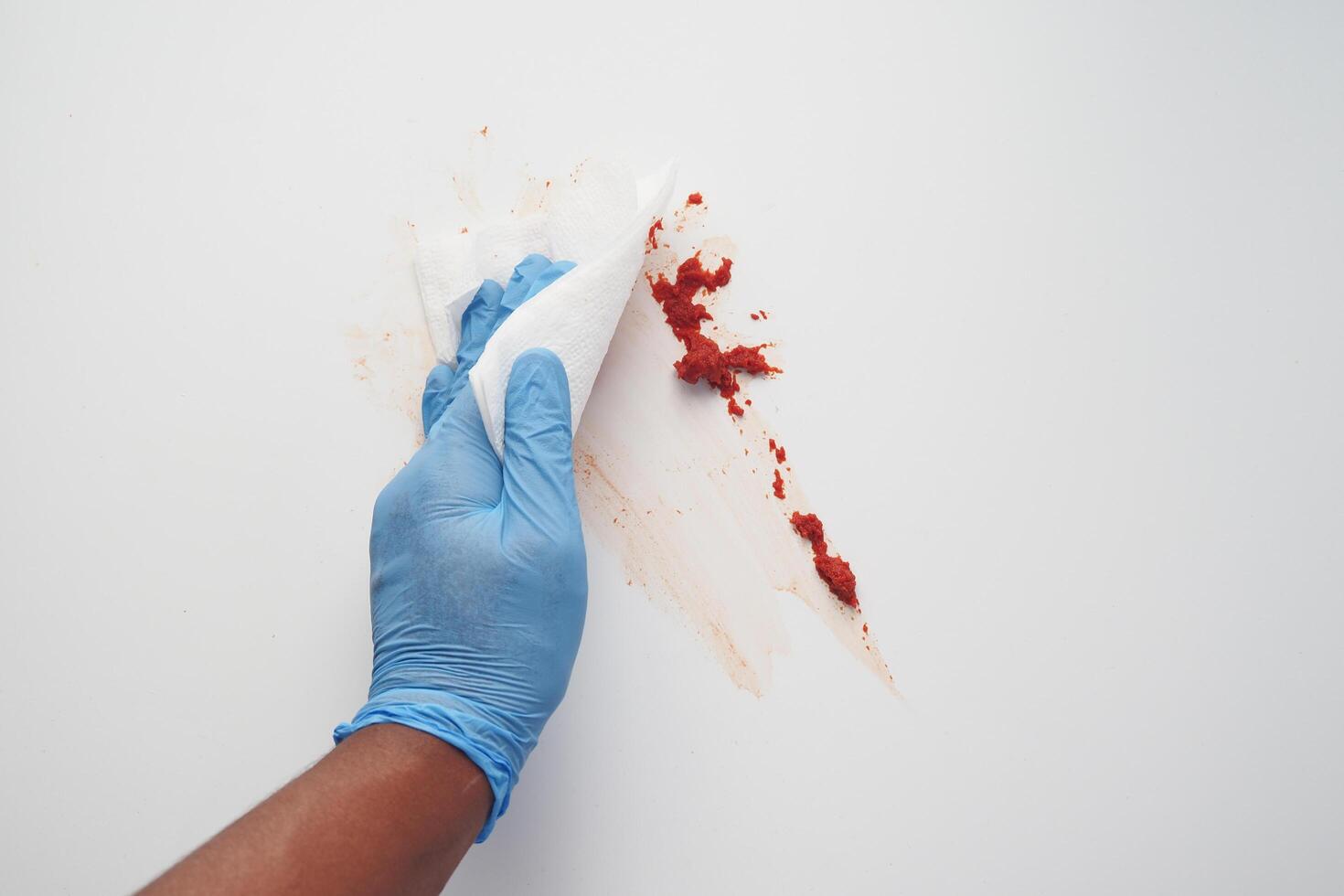 hand in blue rubber gloves cleaning table with cloth photo