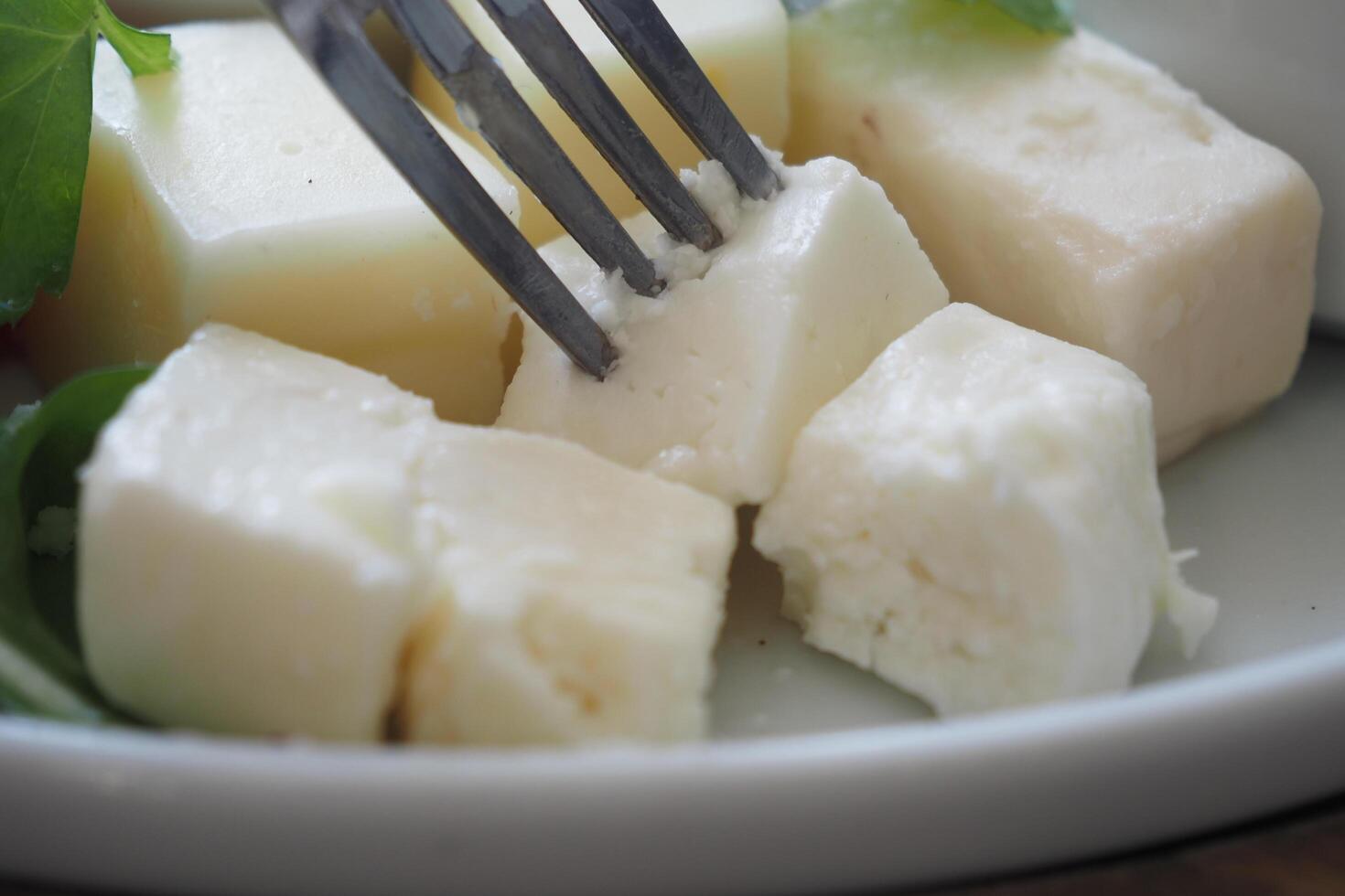 Food plate of cheese cubes and lettuce on checkered tablecloth photo