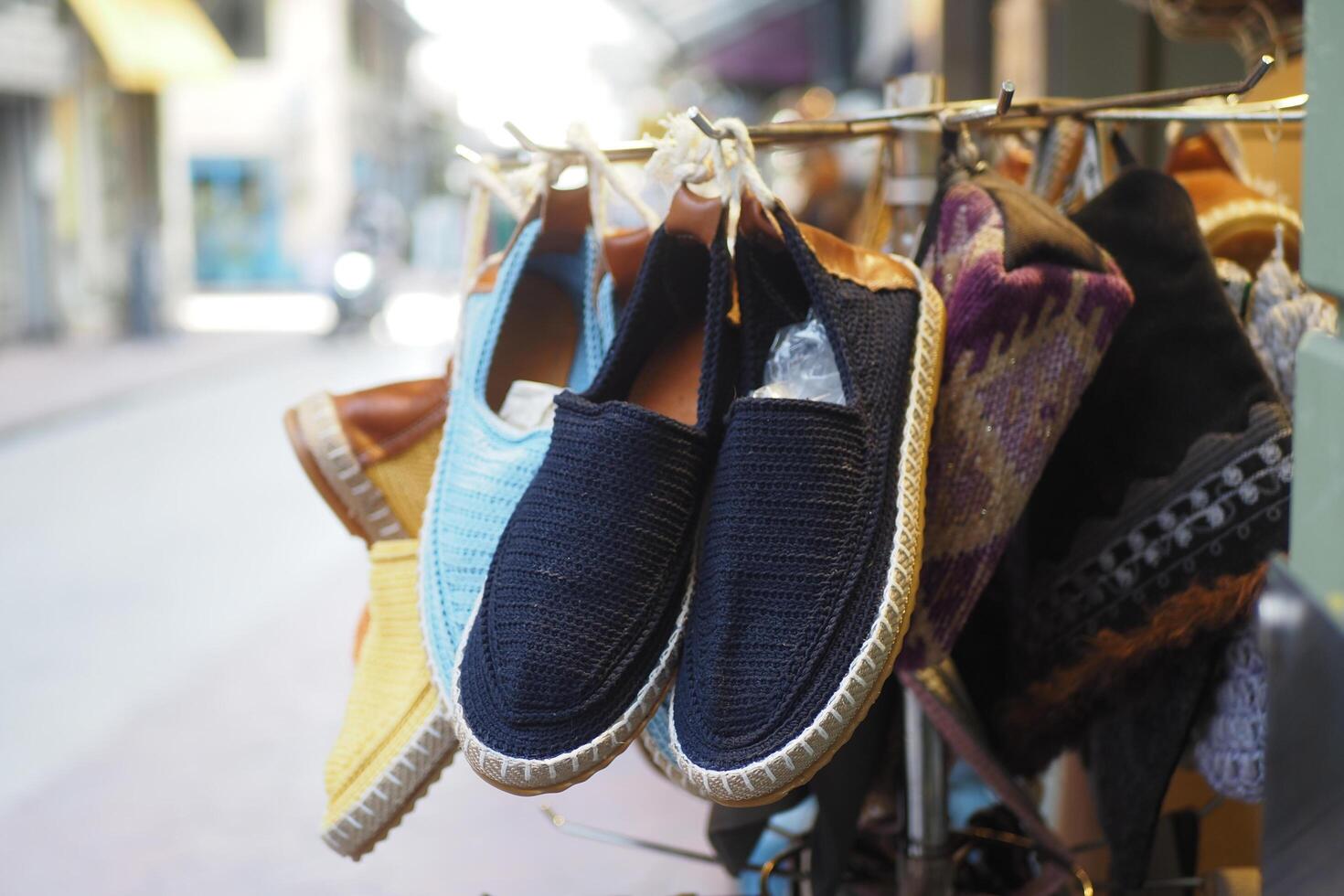 Fashion accessory A variety of shoes hanging on a city street rack photo