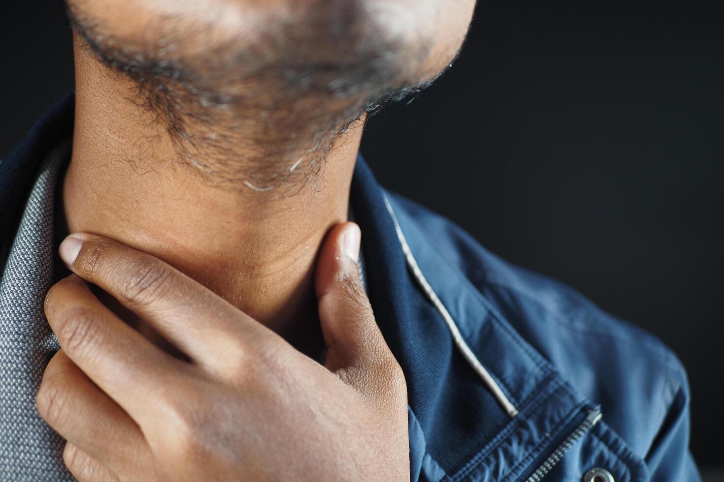 Hombre no reconocido que sufre de dolor de garganta de cerca foto