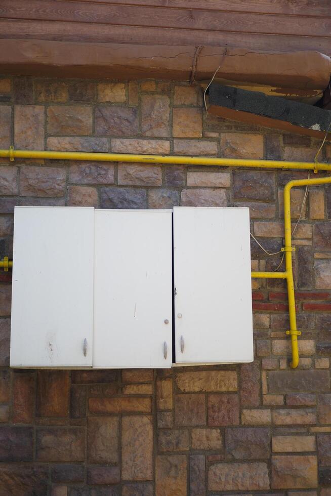 Two electrical boxes with lightning bolt on brick wall photo