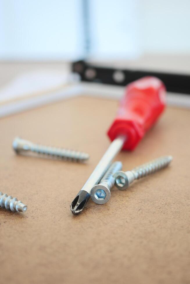 Wooden floor contains like screwdriver and nails in the drawer photo