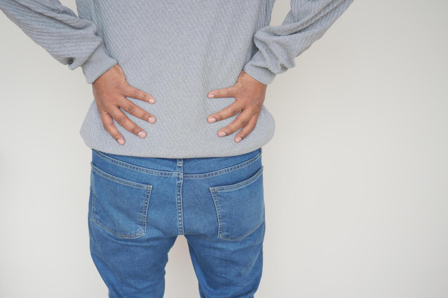 young man suffering back pain close up photo