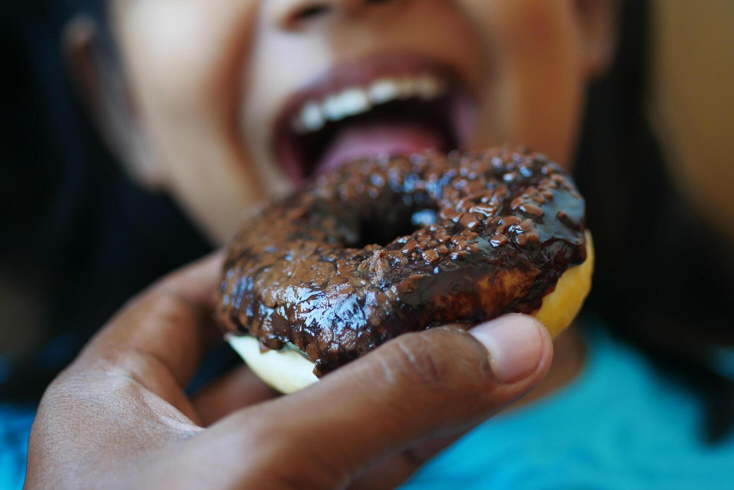 child mouth eating chocolate donuts photo