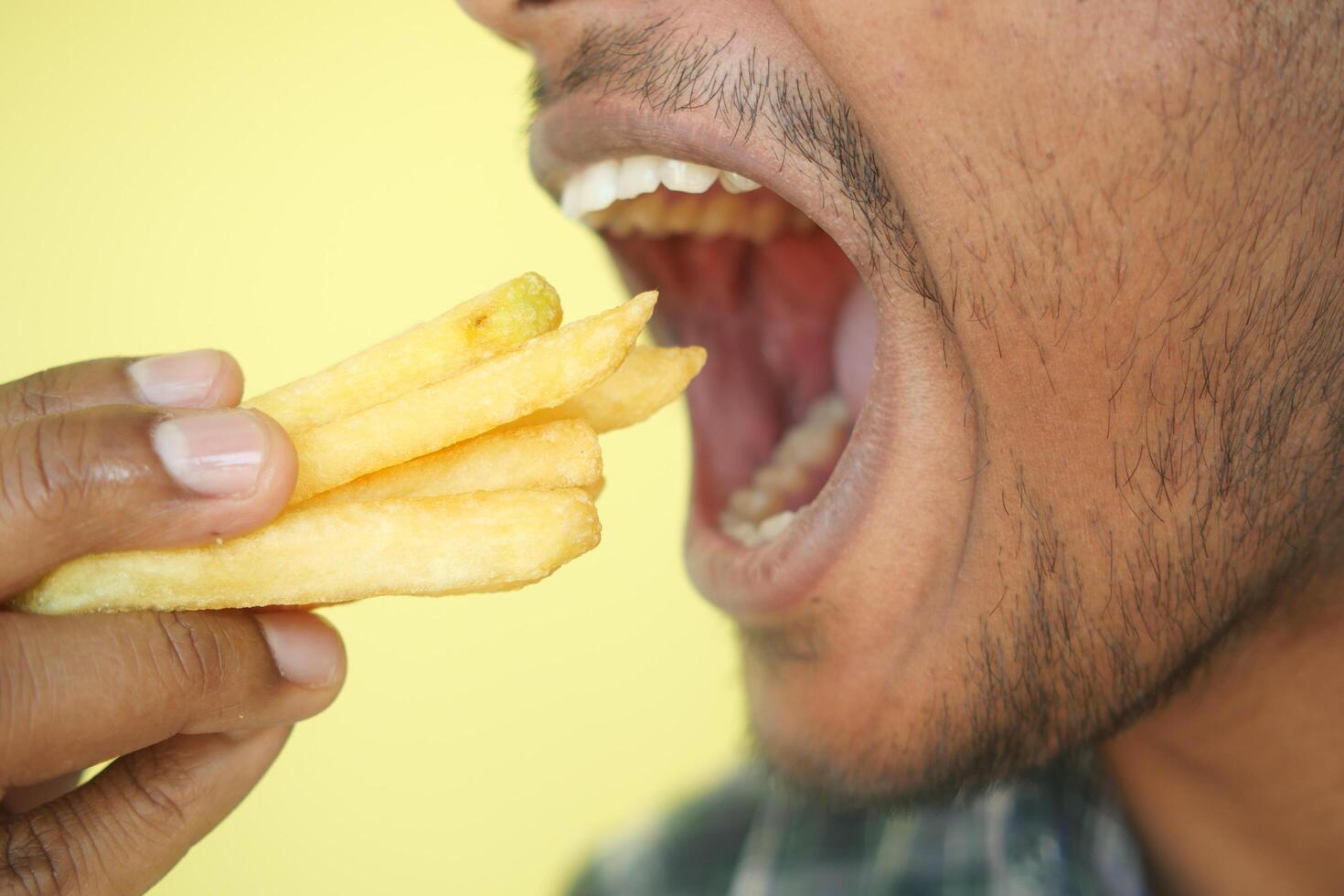 hungry man eating fries closeup photo