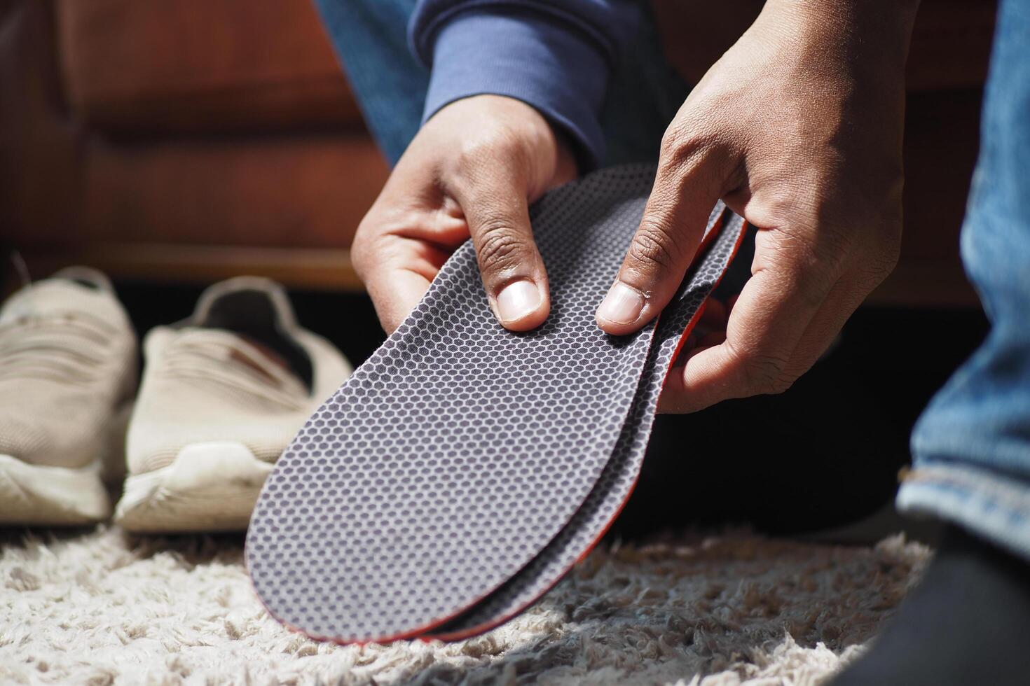 hombres mano poniendo ortopédico plantillas en Zapatos foto