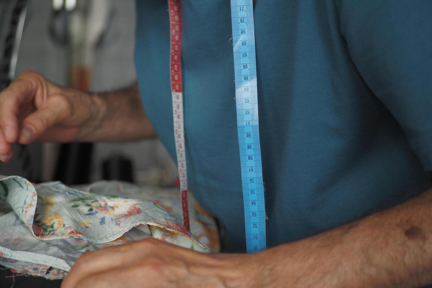 Man measuring fabric with tape measure photo