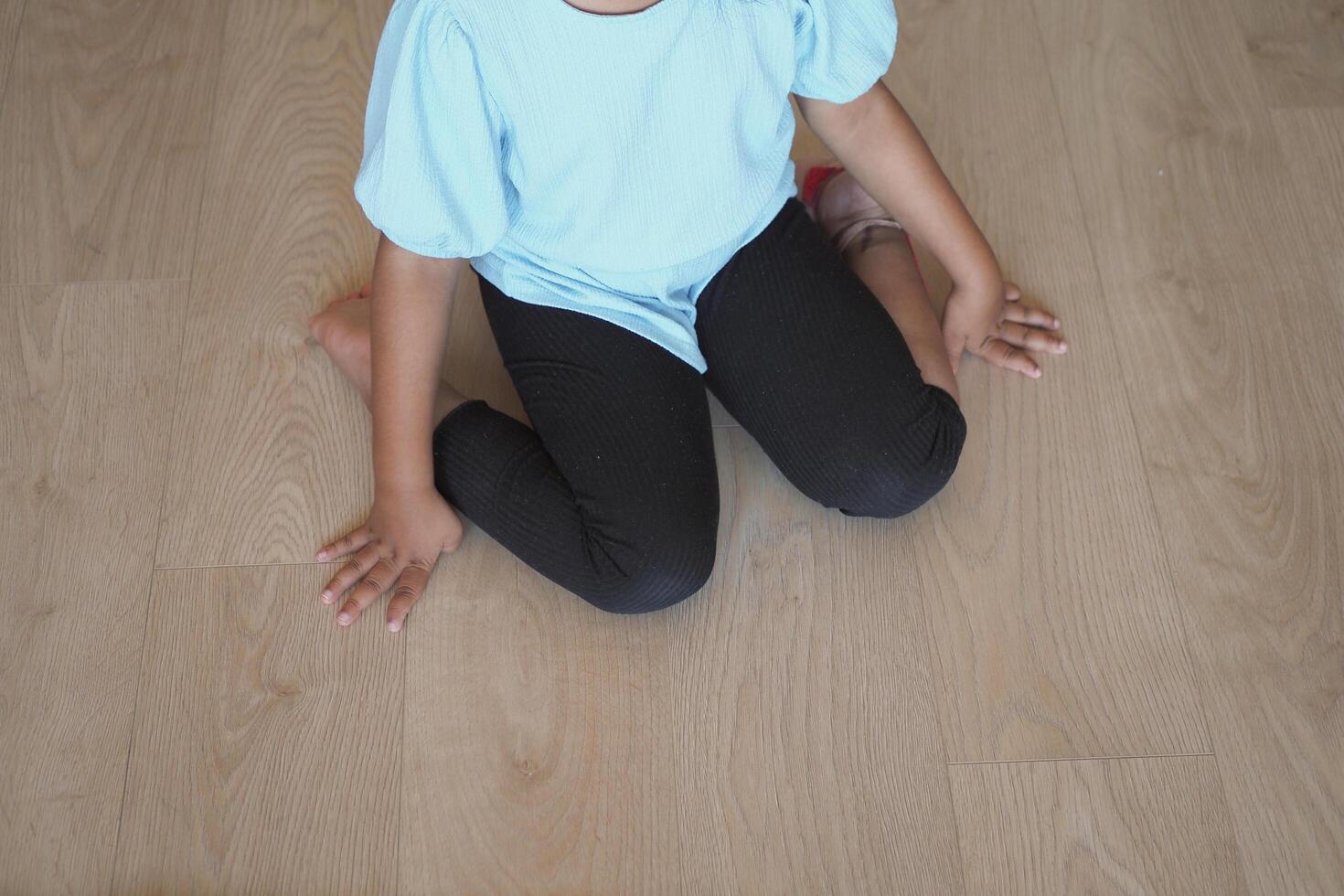 child sitting W posture on the floor . photo
