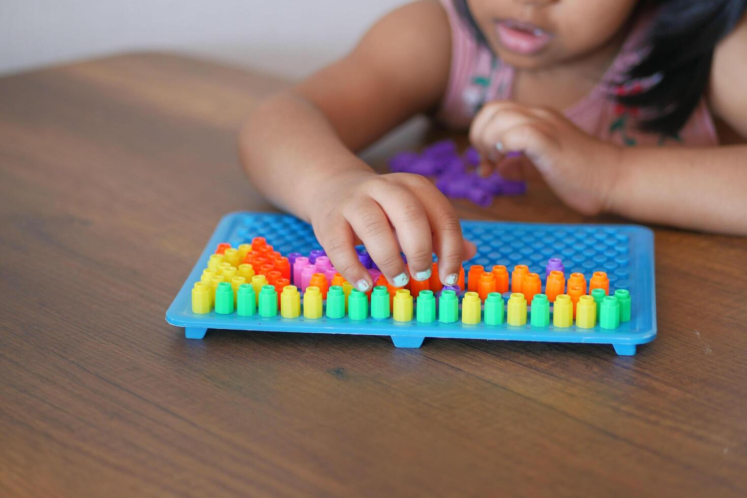 A little girl plays a game, developing motor skills and thinking photo