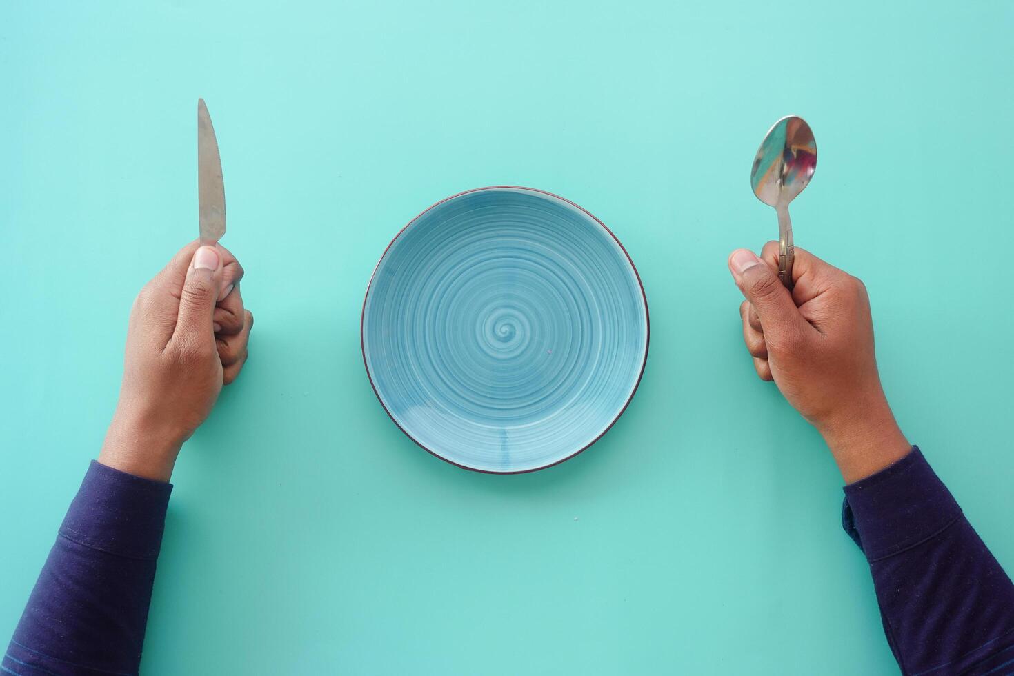 cutlery and empty plate on wooden background top down photo