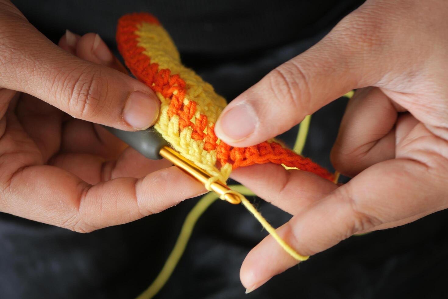 Hand close up crocheting with a hook, wool yarn, creative craft photo