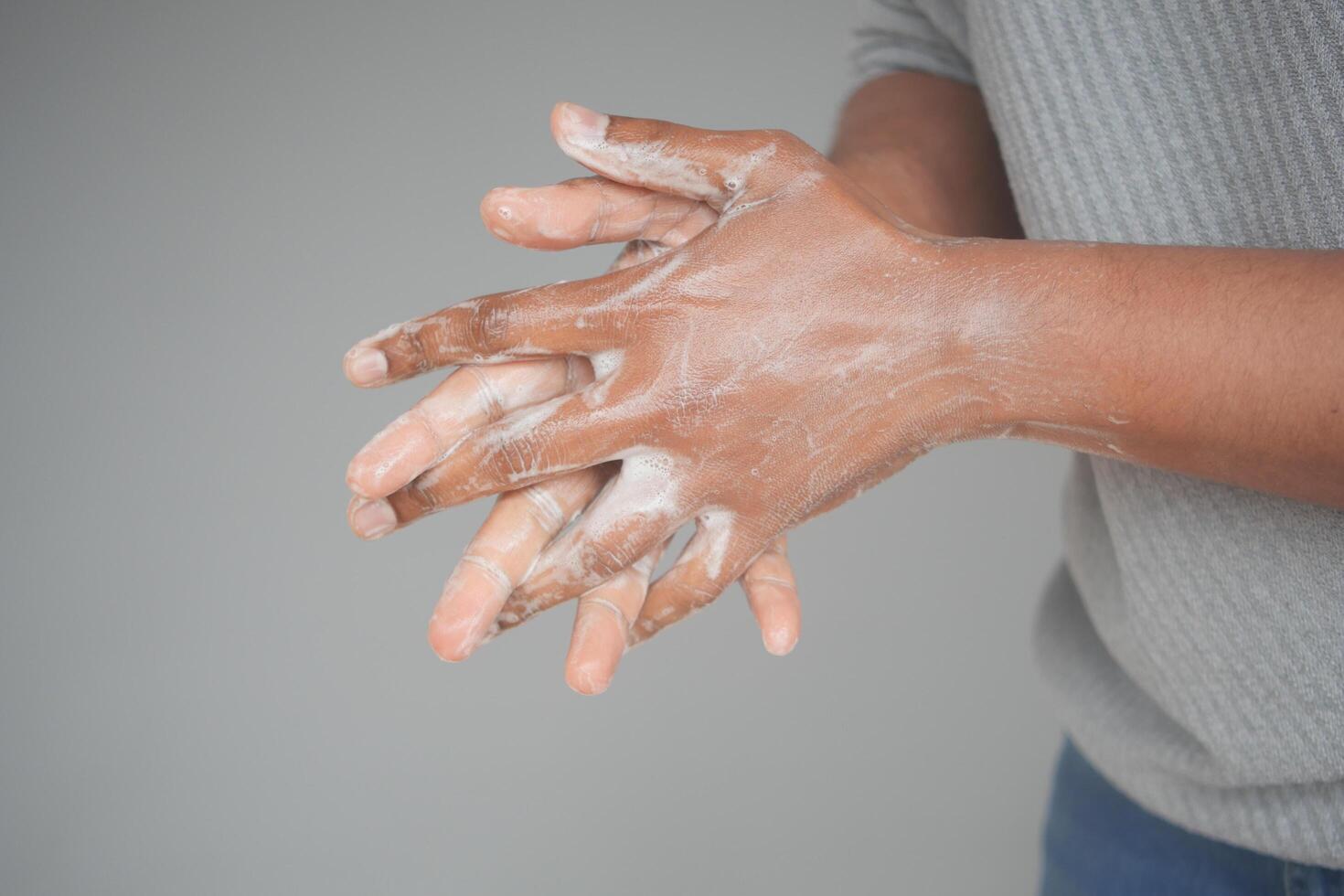 young man washing hands with soap warm water photo