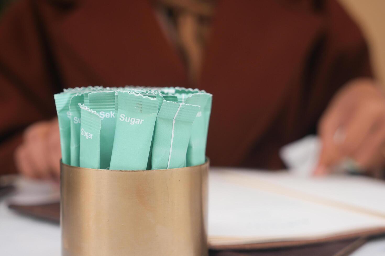 white sugar in a paper packet on table photo