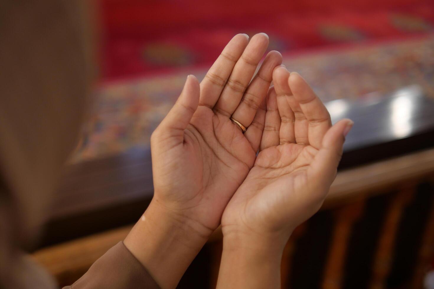 Muslim young woman in hijab is praying in mosque. photo