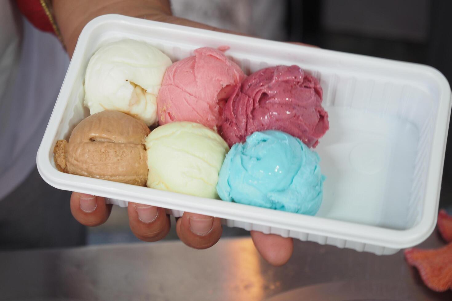 men putting different flavor ice cream in a plastic container photo