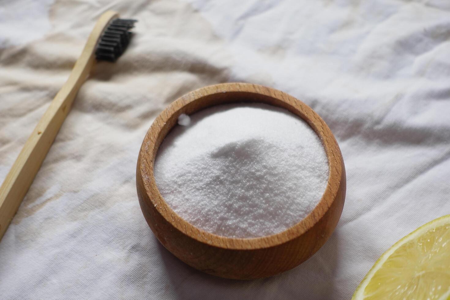 Baking soda and whole lemon on table photo