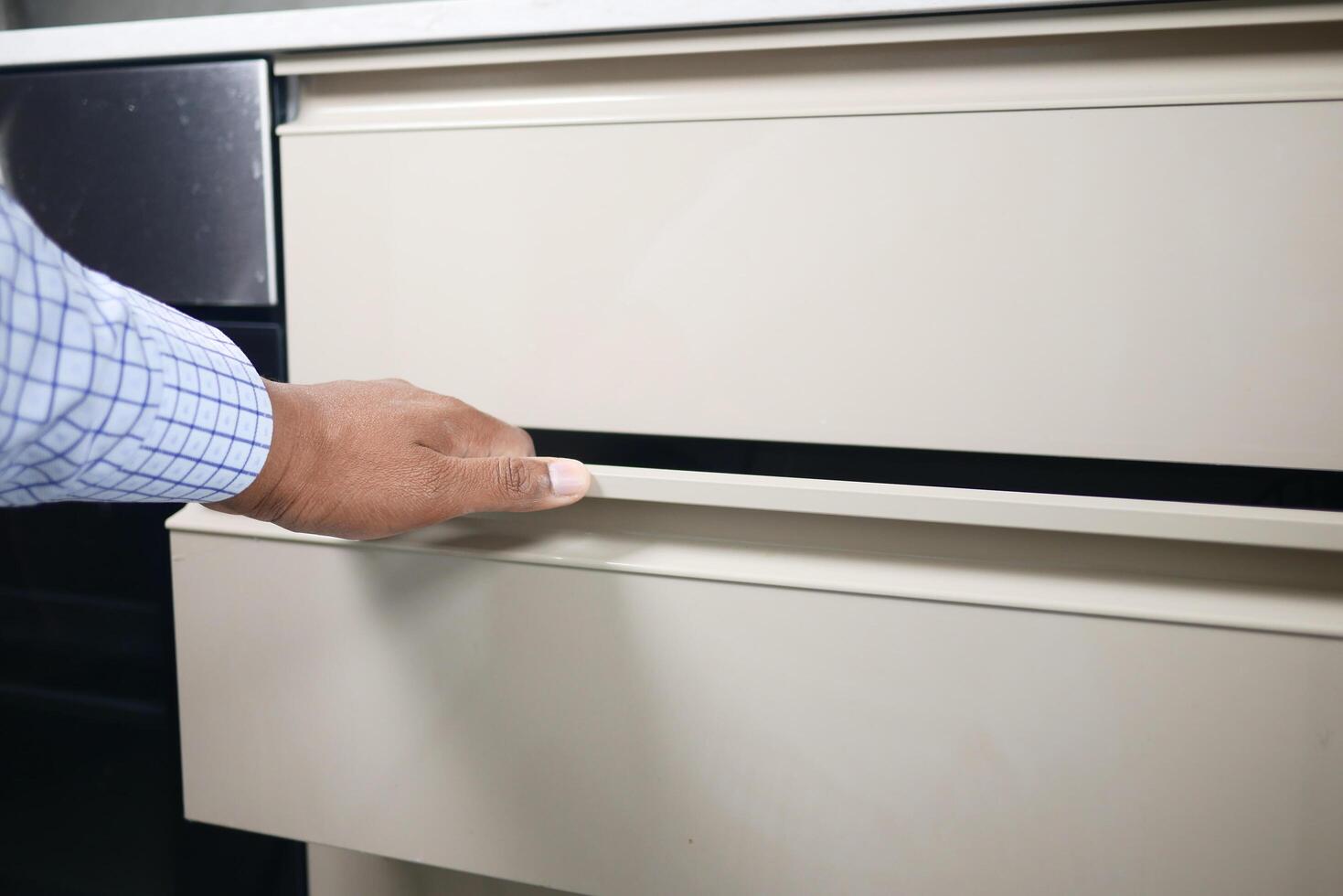 man's hand open drawer wooden in cabinet photo