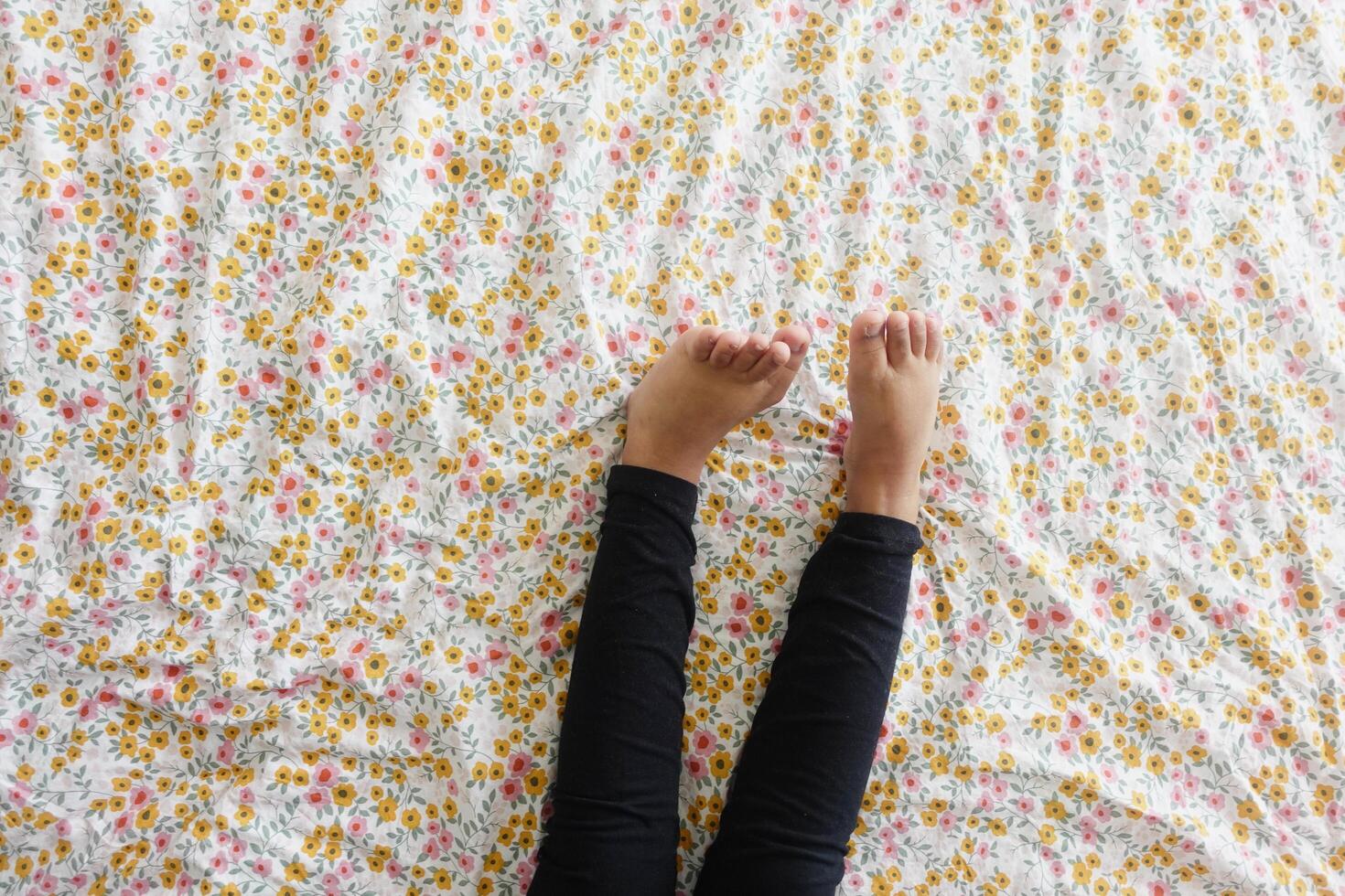 top view of child girl feet on bed photo