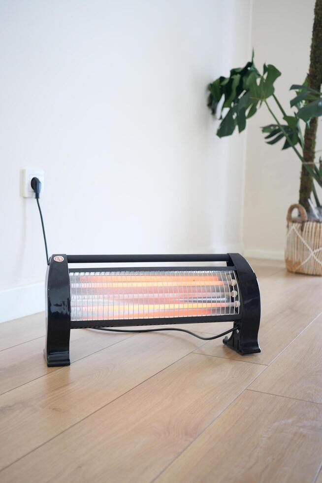 Modern electric infrared heater in living room, closeup photo