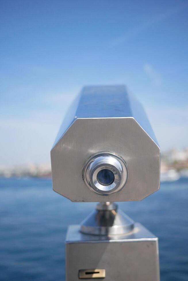 Coin-operated binoculars looking out over city , photo