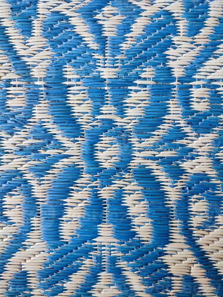 Blue and white woven mat with motif designs on it photo