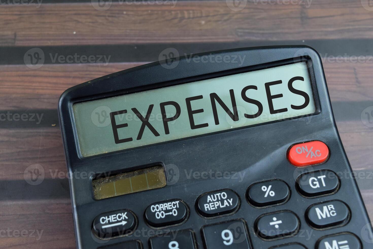 Expenses write on the calculator with wooden background. photo