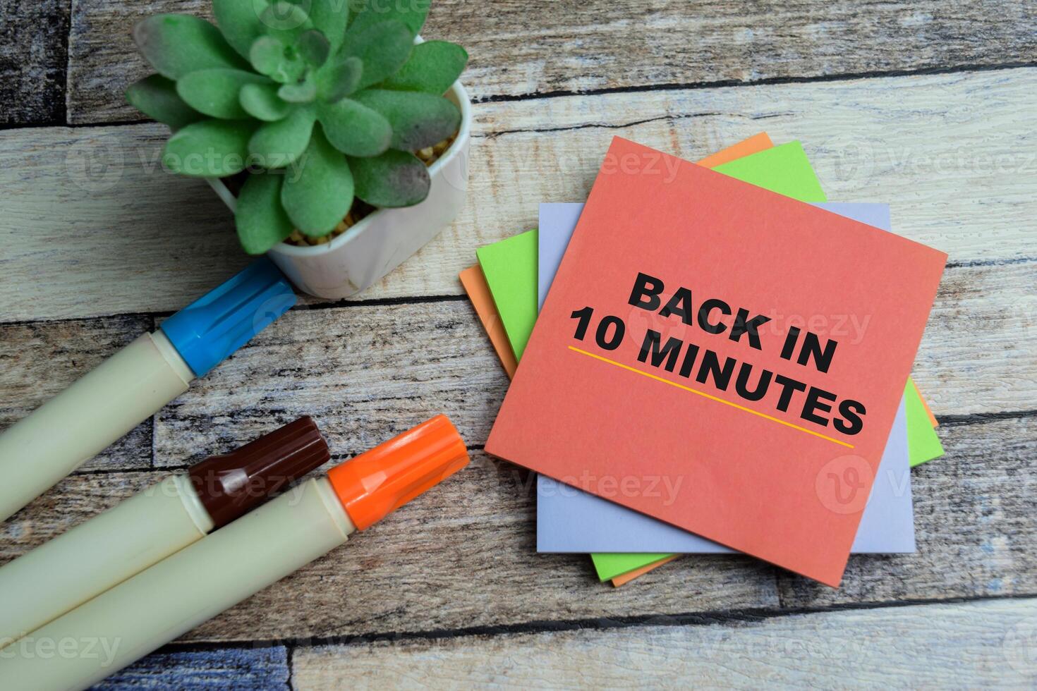 Concept of Back in 10 Minutes write on sticky notes isolated on Wooden Table. photo