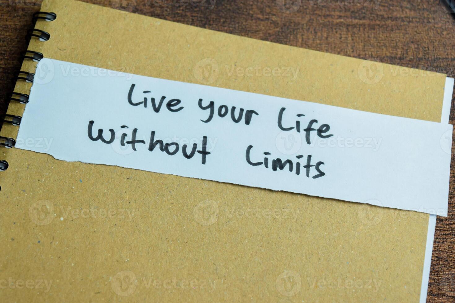 Concept of Live Your Life Without Limits write on sticky notes isolated on Wooden Table. photo